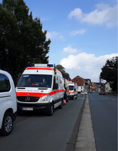 Convoiul de mașini Crucea Roșie pregătite să transporte românii în siguranță la spital.